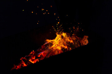 beautiful fire burns with sparks in the night. Bonfire on a black background