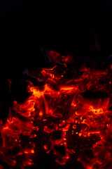 Coals burn in the night. Charcoal smoldering in the dark