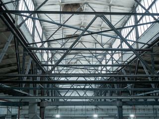 Interior of large industrial hall with metal roof trusses
