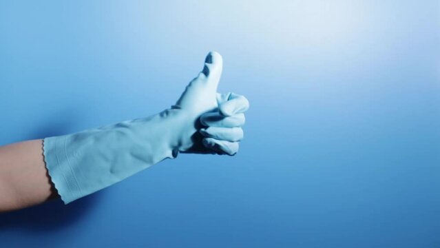 cleaning service, good cleanup, a hand in a glove shows a thumbs up on a blue background