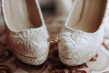 Details of the bride. Beauty is in the details. High-heeled bridal shoes. Gold wedding ring with a...