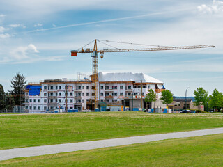 Fototapeta na wymiar New low-rise residential building under construction on blue sky background