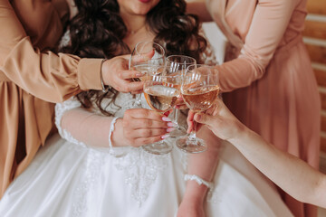 Friends rejoice with the bride in the morning. They take pictures, smile, help the bride fasten her dress.