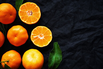 Cut and whole tangerines on a black background - Powered by Adobe