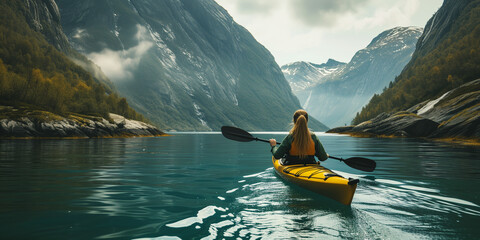 Woman kayaking in a lake with mountains in the background, norwegian nature, Landscape Image with Copy Space - obrazy, fototapety, plakaty