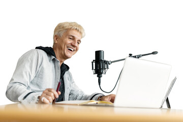 A male presenter is recording a podcast in a recording studio using a microphone and laptop...