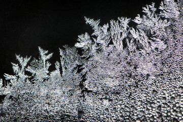 the image of frost on the glass. Subzero temperatures outside. Crystals of frozen water on glass. Beautiful pattern of frost on the window glass. ice, for text or image as background
