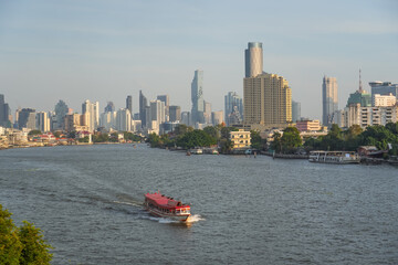 Fototapeta premium Boat ship traffic and tourist taking river cruise on Chao Phraya with skyscraper view sunset time In Bangkok, Thailand.