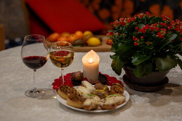 white burning candle and glass of wine, holiday celebration, table decoration