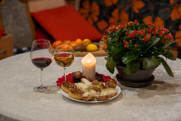 white burning candle and glass of wine, holiday celebration, table decoration