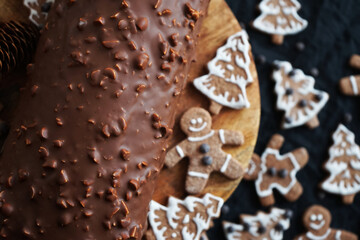 Gingerbread next to a chocolate roll on a dark background