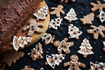 Gingerbread next to a chocolate roll on a dark background