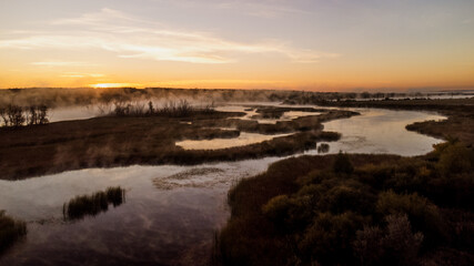 Colorful fog over the lake in autumn at dawn