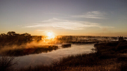 Fototapeta na wymiar Colorful fog over the lake in autumn at dawn