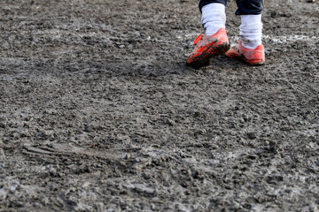 muddy football field with muddy player, detail of an unrecognizable player
