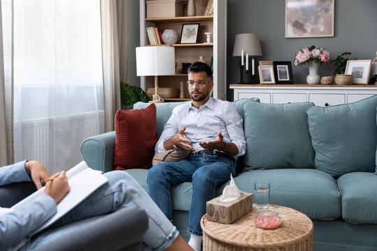 Young businessman undergoing psychotherapy after loss of his job, bankruptcy of private company or the death of a close family member. Man seeks help and a solution from psychotherapist after divorce.