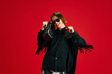 Young, overjoyed, cool attitude man listening popular music from vintage tape recorder and dancing...