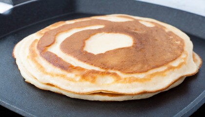 cooking wheat pancakes for american breakfast on black griddle