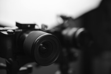 Video cameras on tripods, selective focus, Studio soft box, light. Filming, work of a videographer. hardware Radio microphone, receiver, directional microphone. Black and white.