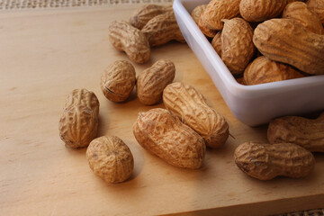Fresh roasted peanuts on wooden table.