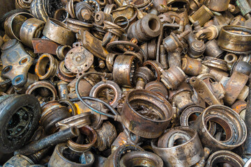 rusted steel scrap pile of used car parts and pieces - full-frame closeup background and texture