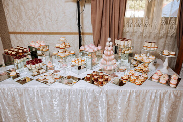 Almond cookies and various sweet cakes for a wedding banquet. A delicious reception, a luxurious ceremony. Table with sweets and desserts. Delicious colorful French desserts on a plate or table.
