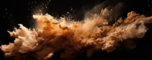 Explosion of beige brown colored powder on black background