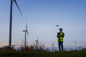 Person with UAV in wind turbine field. silhouette of a person in the sunset. silhouette of a person.