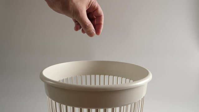 The packaging from the dental floss is thrown into the trash for disposal