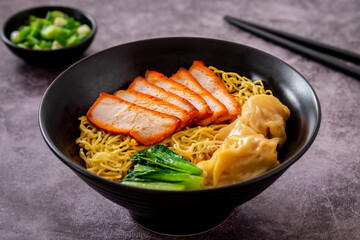 Egg noodle with red roasted pork and wonton in black bowl