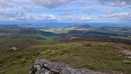 From the mountaintop, Wicklow's countryside unfolds—an exquisite canvas of rolling hills and lush greenery beneath the open sky.