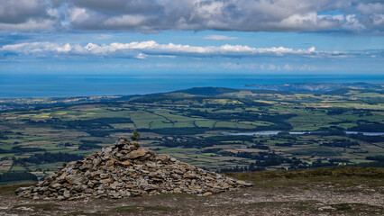 From Djouce Peak's vantage: Wicklow's rolling countryside unfolds like a patchwork quilt, a serene testament to Ireland's natural splendor.