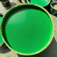A large can of green oil colour on a concrete floor, renovation in an apartment.