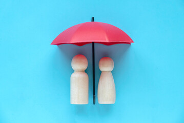 A couple under a red umbrella. Health and life insurance concept.