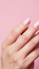 Fototapeta premium Close-up of a woman's hand with a delicate pink manicure. Beauty, cosmetics, makeup concepts.