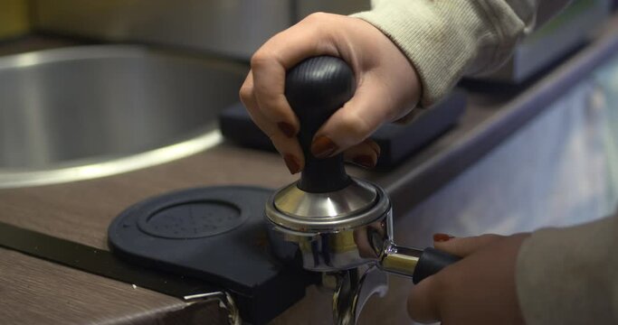 Coffee barista tamping compressing grinds in puck before extraction