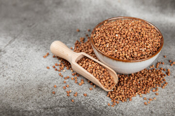 Buckwheat porridge in a bowl on a dark texture background. Healthy food. Diet. Organic cereal.
 Raw buckwheat. gluten free ancient grain for healthy diet. Place for text. Copy space.