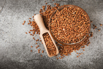 Buckwheat porridge in a bowl on a dark texture background. Healthy food. Diet. Organic cereal.
 Raw buckwheat. gluten free ancient grain for healthy diet. Place for text. Copy space.