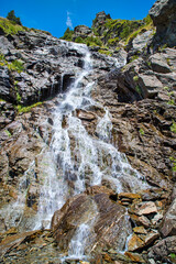 Rocky waterfall during summer - 703418030