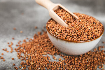 Buckwheat porridge in a bowl on a dark texture background. Healthy food. Diet. Organic cereal.
 Raw buckwheat. gluten free ancient grain for healthy diet. Place for text. Copy space.