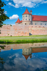 Summer scene with mirroring fortress - 703418052