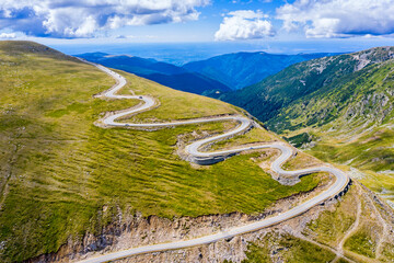 Road in alpine range, passing way in Romanian Carpathian - 703418207