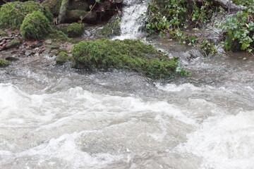 Ein Bach nach ergiebigen Regen mit Felsen und Steinen und ein Bach ohne Wasser nur Steine