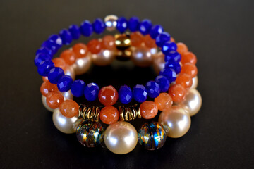 A set of beaded bracelets on a black surface