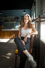 A woman sitting on a chair indoors, smiling. 4676