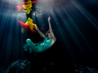 Halee Grindo swimming underwater with long dresss and chiffon