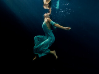 Obraz premium Halee Grindo swimming underwater with long dresss and chiffon