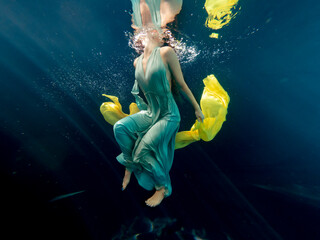 Halee Grindo swimming underwater with long dresss and chiffon