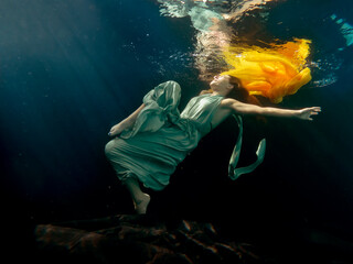 Halee Grindo swimming underwater with long dresss and chiffon
