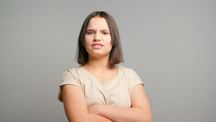 Obraz premium Picture of angry young latin woman standing isolated over gray background. Looking at camera